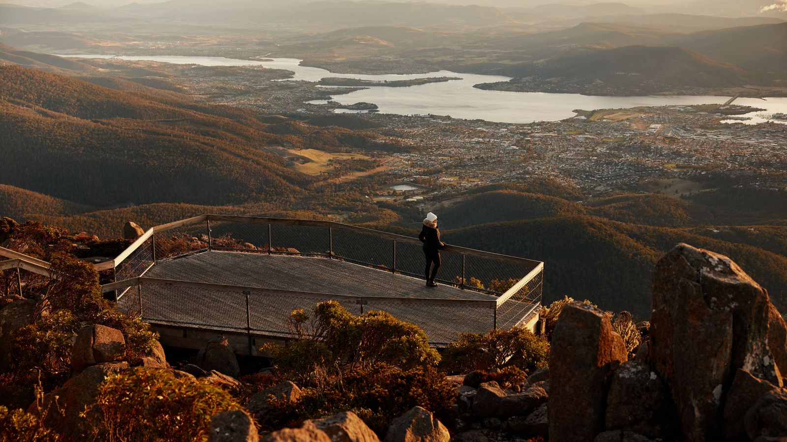 Visitor standing on the Pinnacle viewing platform overlooking Hobart and the Derwent Estuary.